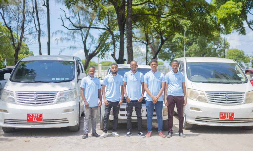 ZanDrive Car Rental team with their vehicle in Zanzibar offering professional airport transfer services