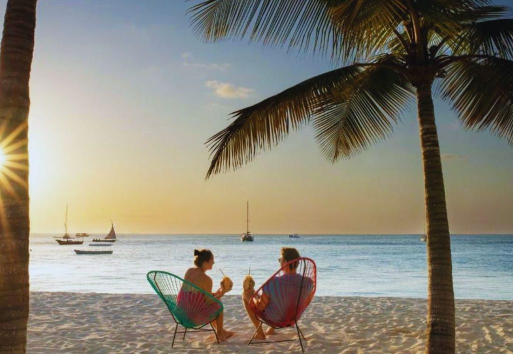 Couple enjoying a Zanzibar beach trip after renting a car for island exploration